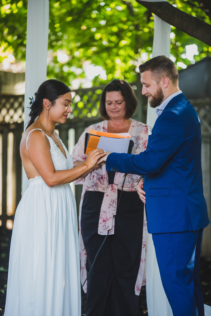groom putting ring on bride's finger