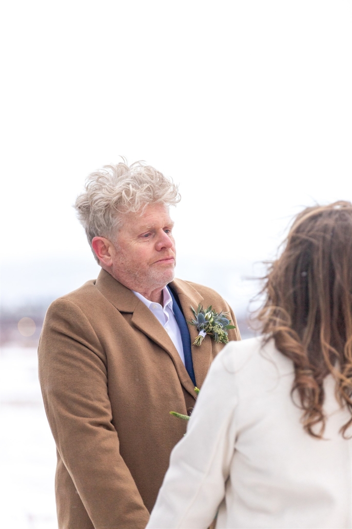 groom looking at bride in winter wedding ceremony